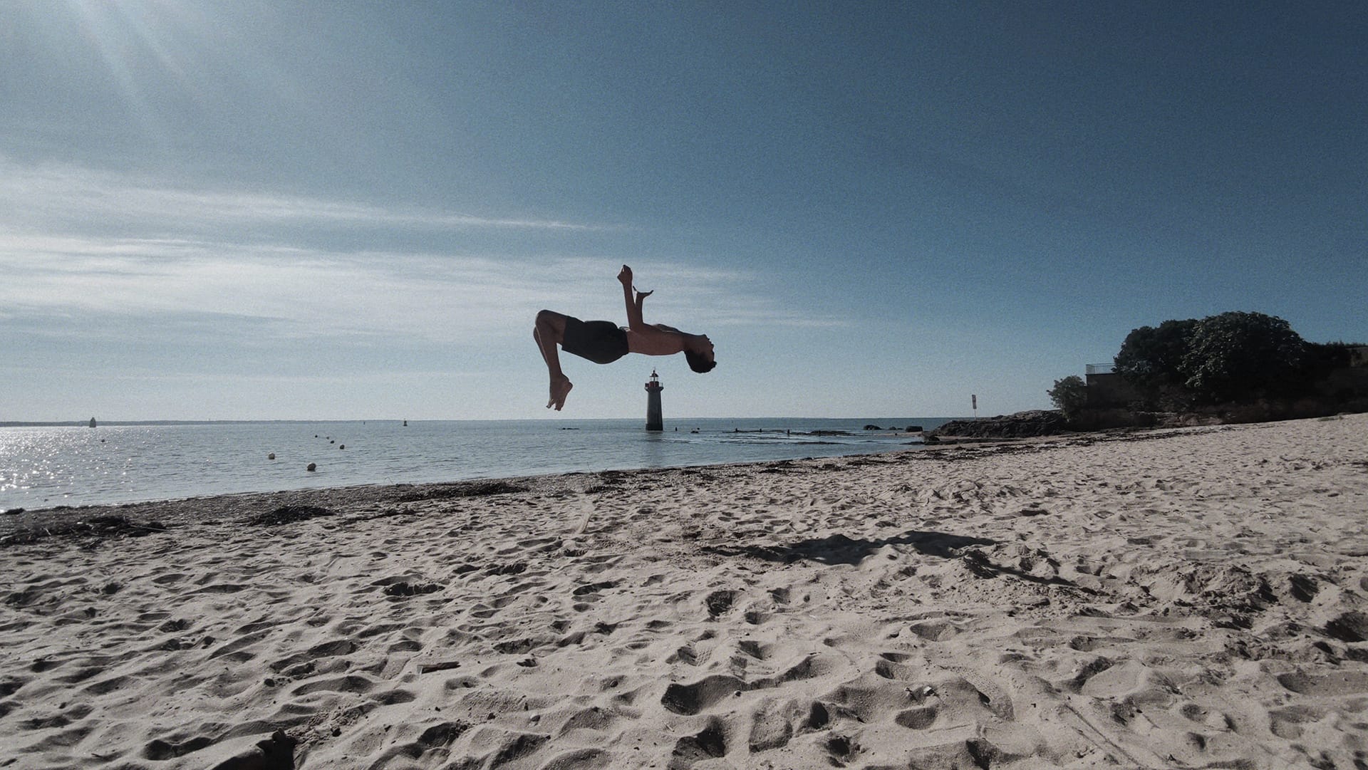 Saut sur une plage de Saint-Nazaire, face au phare